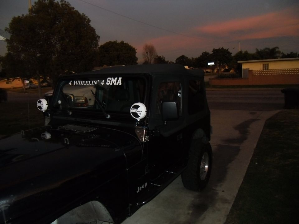 Black 1992 Jeep Wrangler with '4 Wheelin' 4 SMA' decal on windshield and two round auxiliary lights