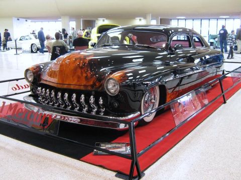 2000 Mercury Grand Marquis - A heavily customized classic car with a prominent grille and flame paint job is on display.