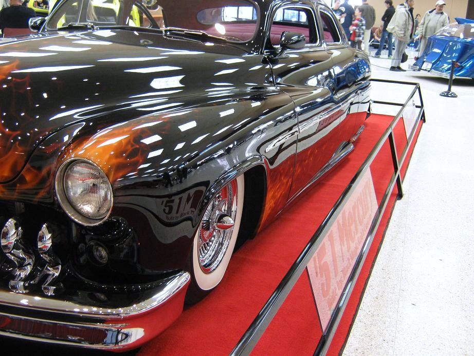 Black hot rod with flame paint, chrome grille, and whitewall tires