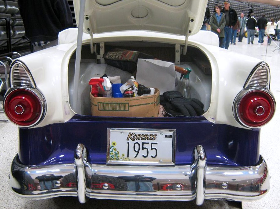 1955 car rear with open trunk showing cleaning supplies and gloves