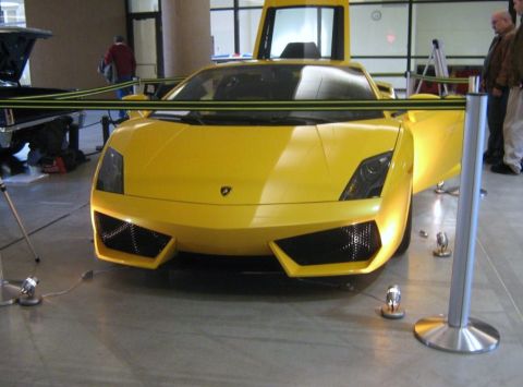 2000 Mercury Grand Marquis - A bright yellow Lamborghini Gallardo is displayed with its doors raised, its front end.