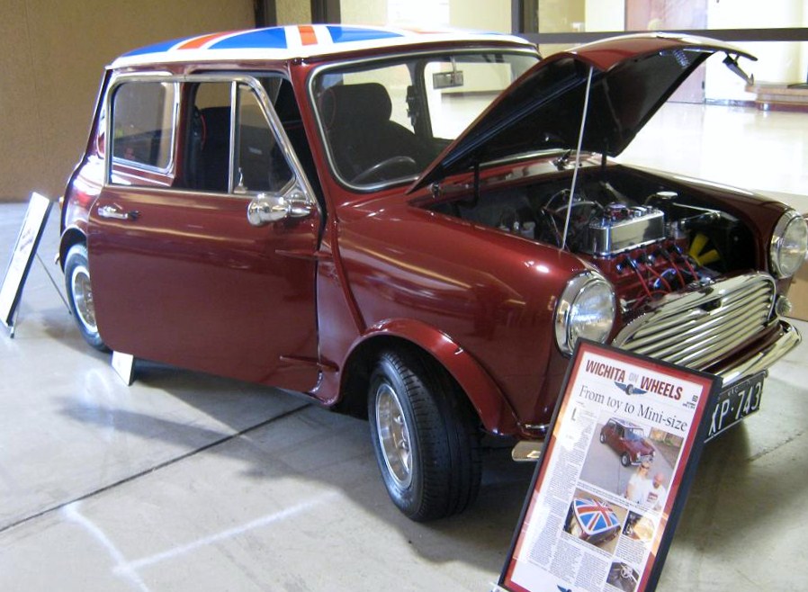 Maroon classic Mini with Union Jack roof and chrome engine swap on car show display
