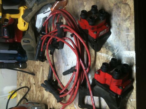 1997 Lincoln Town Car - Ignition coils and spark plug wires are displayed on a workbench.