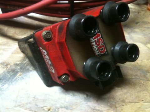1997 Lincoln Town Car - This MSD ignition coil features a red housing and four black spark plug wire boots, indicating it is a performance automotive part.