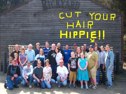 2007 Ford Mustang - A group of people pose for a photo in front of a rustic wooden building, with a humorous message painted above them.