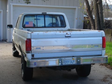 1989 Ford F-250 - Rear view of a white 1987 Ford F-250 pickup truck with a chrome bumper and a license plate.