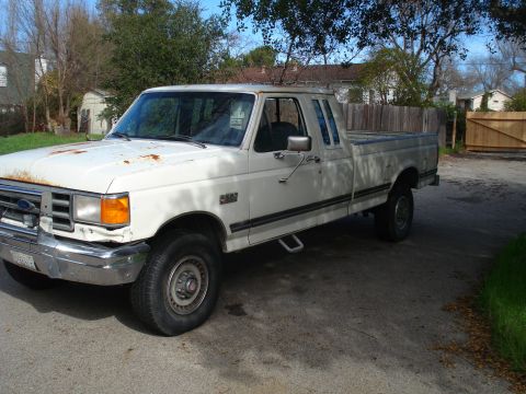 1989 Ford F-250 - This white Ford F-250 pickup truck, seen from a 3q-front angle, appears to be from the 1987 model year, not 1989 as claimed.