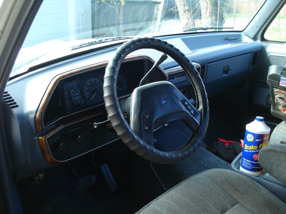1989 Ford F-250 interior showing dashboard, steering wheel, and brake fluid bottle