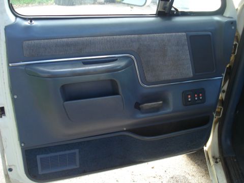 1989 Ford F-250 - The interior door panel of a 1989 Ford F-250 features blue fabric inserts and power window controls.