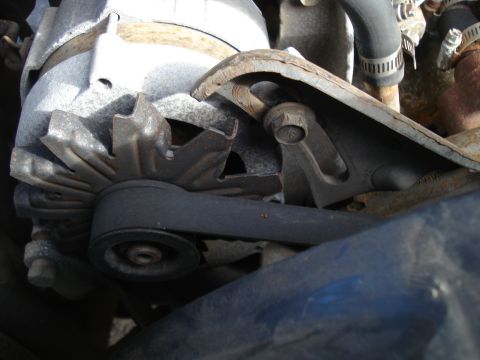1989 Ford F-250 - Close-up view of an engine's alternator and drive belt system.