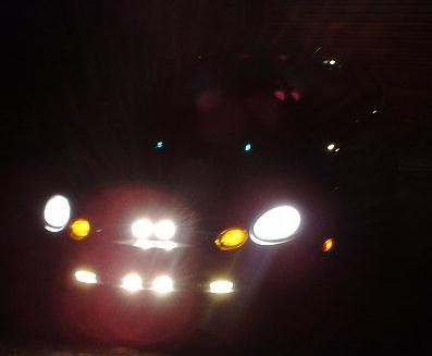 1997 Ford Taurus - The front of a vehicle is illuminated by its headlights and fog lights at night.
