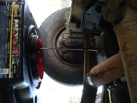 1989 Ford F-250 - Changing the oil on a vehicle, focusing on the oil pan and surrounding undercarriage components.