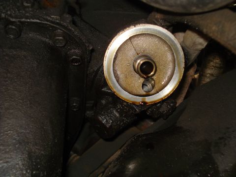 1989 Ford F-250 - Close-up view of an oil filter adapter, showing signs of oil leakage.