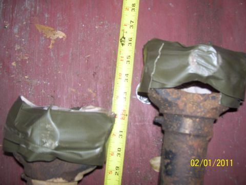 1978 Ford Bronco - Close-up of two automotive axle components, one larger than the other, with a measuring tape for scale.