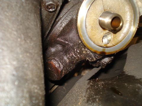 1989 Ford F-250 - Close-up of an engine's oil filter housing showing signs of oil leakage.