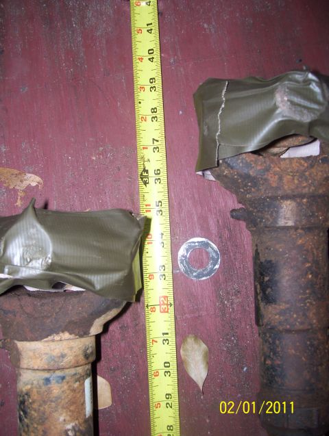 1978 Ford Bronco - Two axle shafts are shown with a tape measure for scale, indicating their length.