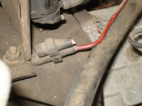 1989 Ford F-250 - A frayed red wire is visible, connected to a gray electrical plug within the engine compartment.