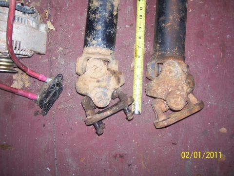 1978 Ford Bronco - Close-up of driveshaft components and an alternator, with a measuring tape for scale.