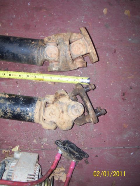 1978 Ford Bronco - Close-up of two used driveshaft components, one with a measuring tape.