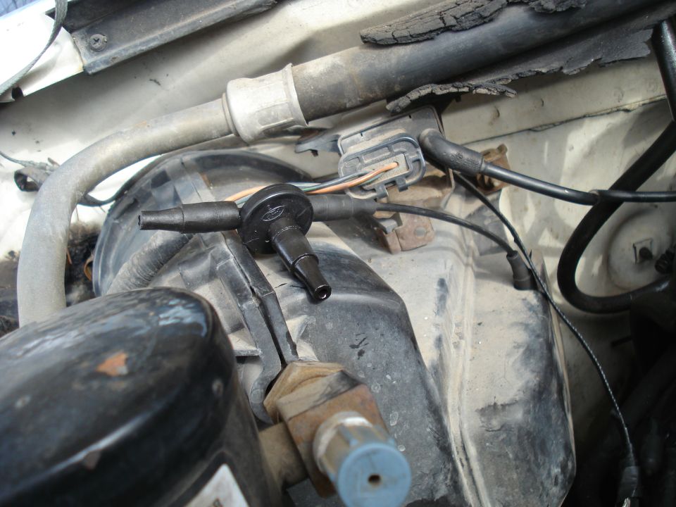 Close-up of vacuum lines and electrical connectors in a vehicle's engine bay