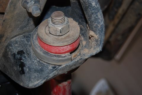 1982 Ford Bronco - This image shows a close-up view of a vehicle's suspension system, focusing on a red bushing.