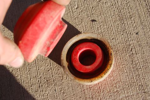 1982 Ford Bronco - A red rubber bushing is shown next to its housing, with visible part numbers on the inner bushing.