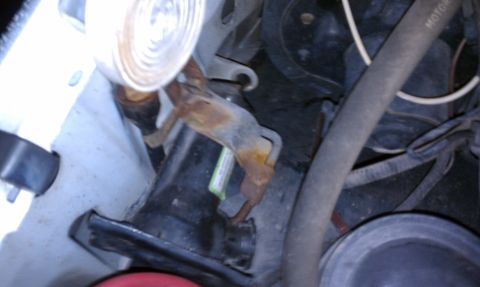 1996 Ford Bronco - Engine bay detail showing a corroded bracket and various hoses.