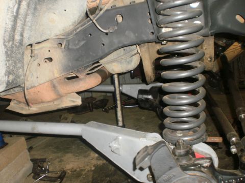 1995 Ford Bronco - Close-up view of a vehicle's suspension system, focusing on the coil spring and frame.