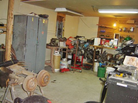 1984 Ford Mustang - Garage scene filled with various automotive parts, tools, and storage units.