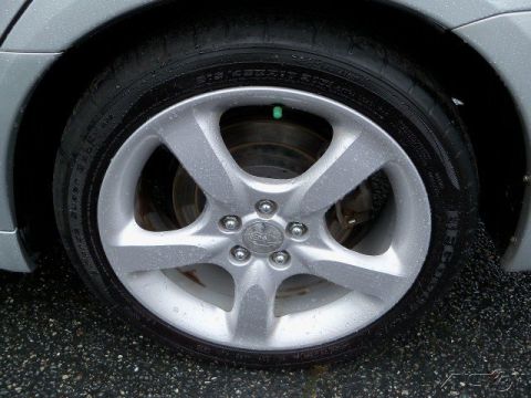 2006 Subaru Legacy - Detail shot of a car's wheel and tire assembly, showing the alloy rim and tread on a wet surface.