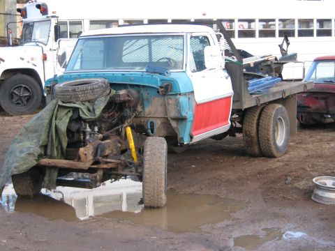 1972 Ford F-250 - This truck is in a state of disrepair, with its front end dismantled and parked in a muddy lot.