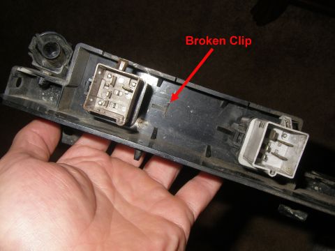 1990 Ford Bronco - A hand holds a car part with two electrical connectors and a red arrow pointing to a broken clip.