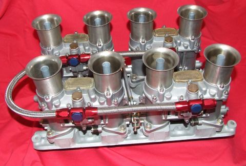 1973 Ford Mustang - A quad barrel carburetor assembly, likely for a performance application, is shown against a red background.