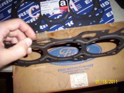 1993 Ford Probe - Close-up of an engine gasket being held, with packaging and a Ford Motor Company box visible.