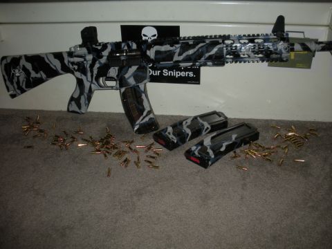 1996 Ford Bronco - An assault rifle with a distinctive camouflage pattern is displayed with ammunition and magazines.