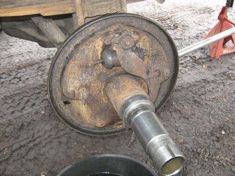 1972 Ford F-250 - Close-up view of a rusty brake drum and axle assembly, possibly undergoing maintenance or repair.