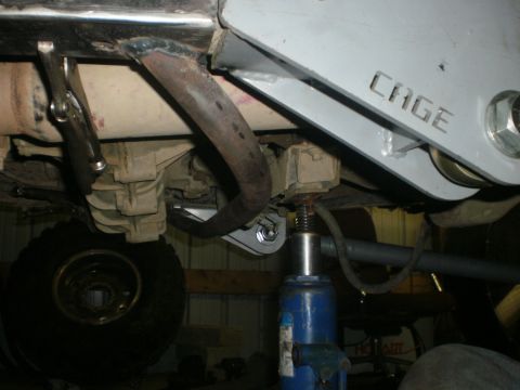1995 Ford Bronco - Undercarriage view shows a jack supporting the frame near the transmission and exhaust.
