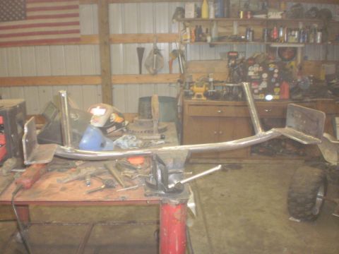 1995 Ford Bronco - A custom metal crossmember is being worked on in a cluttered garage setting.
