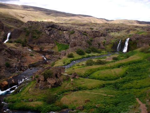 1996 Ford Bronco - A scenic view of a canyon with multiple waterfalls and a winding stream through lush green vegetation.