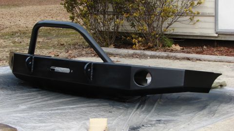 1995 Ford Bronco - This aftermarket bumper features a brush guard and a cutout for a winch, suggesting it's designed for off-road use.