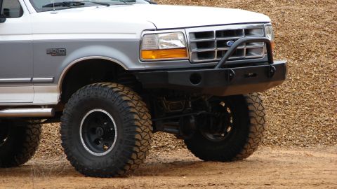 1995 Ford Bronco - Front view of a lifted Ford Bronco with a custom bumper and off-road tires.
