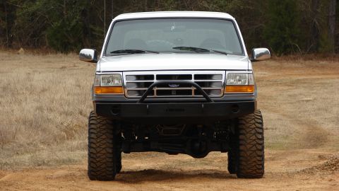 1995 Ford Bronco - This 1995 Ford Bronco features a lifted suspension, large off-road tires, and a custom front bumper.