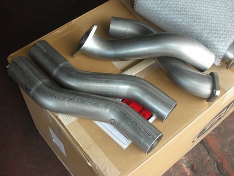 2004 Ford Crown Victoria - Stainless steel exhaust pipes, likely for a vehicle, are laid out on a cardboard box.