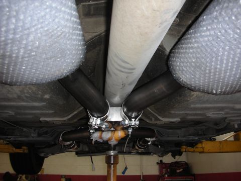 2004 Ford Crown Victoria - Custom exhaust system installed on a vehicle, showing the dual pipes leading to mufflers.