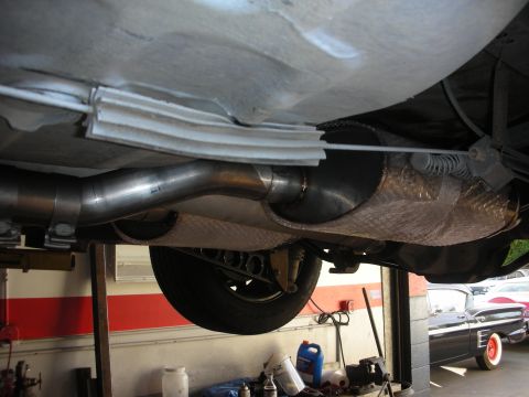 2004 Ford Crown Victoria - A vehicle's undercarriage and exhaust system are viewed from below, with another car visible in the background.