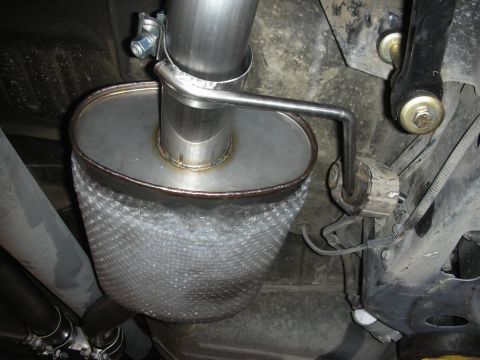 2004 Ford Crown Victoria - Underside view of a custom exhaust system component, likely a muffler and piping.