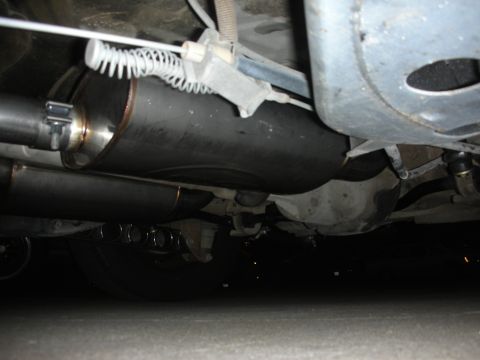 2004 Ford Crown Victoria - Close-up view of the exhaust system, including a muffler and pipes, on the underside of a vehicle.
