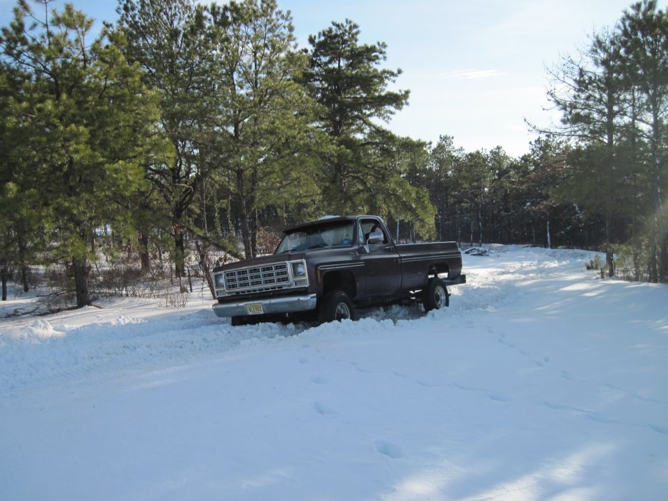 1973 Chevrolet pickup truck driving in snow, front grille visible