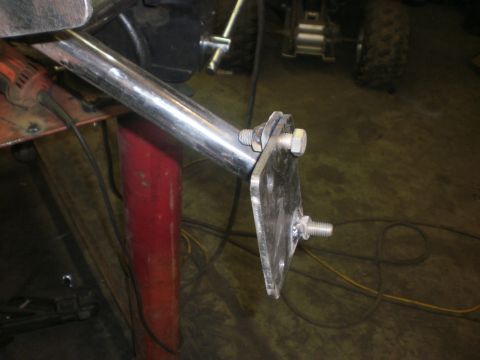 1995 Ford Bronco - Close-up of a shop-fabricated bracket in progress: a polished stainless tube clamped to a bare aluminum triangular mounting plate with hex…