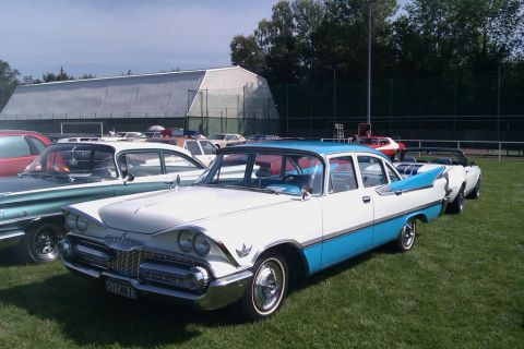 1991 Ford LTD Crown Victoria - A two-tone 1959 Dodge sedan is parked on a grassy field with other vehicles in the background.